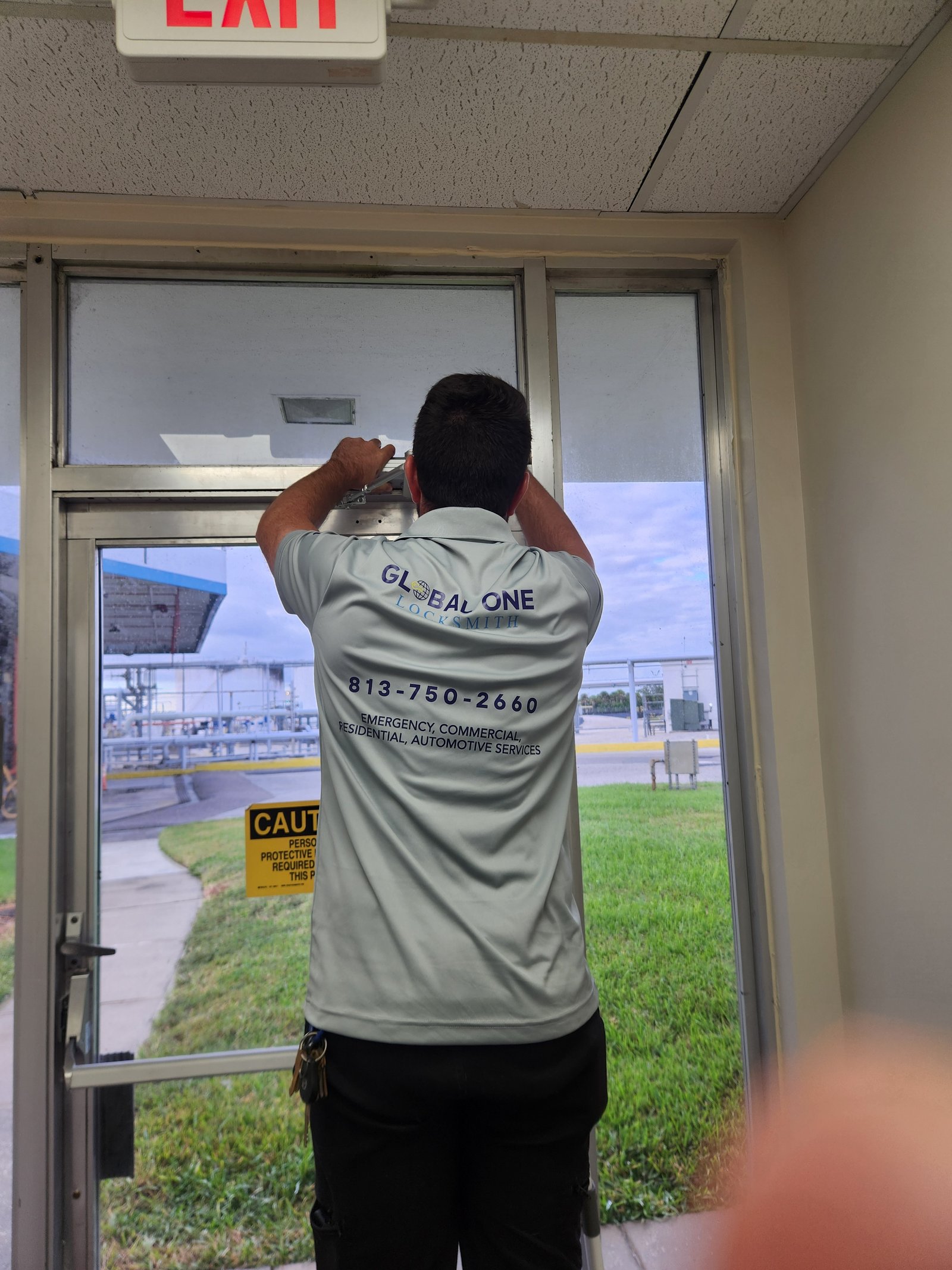 Technician working on commercial glass door lock installation